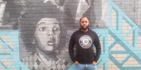 Saadiq Newton-Boyd with mural in Brooklyn